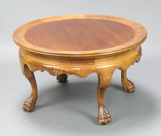A circular Eastern hardwood dish shaped coffee table raised on cabriole and paw supports 47cm h x 82cm diam. 
