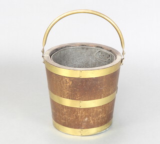 A 1920's circular oak and brass coopered coal bucket with swing handle, with zinc liner (holes to liner)  31cm x 32cm 