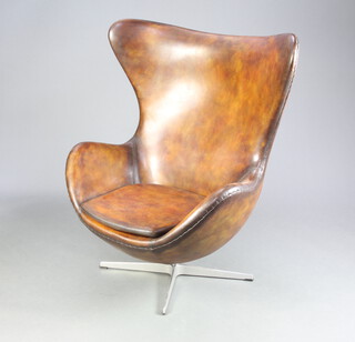 After Arne Jacobsen, an egg chair upholstered in brown leather 105cm h x 79cm w x 46cm d  (seat 35cm x 38cm) 