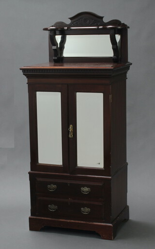 An Edwardian mahogany cabinet, the shaped back fitted a bevelled plate mirror with dentilled decoration, the base enclosed by a rectangular bevelled plate mirror panelled doors and fitted 2 drawers, raised on bracket feet 152cm h x 65cm w x 47cm d 