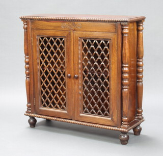 A Regency style hardwood side cabinet fitted a shelf enclosed by lattice work panels, raised on bun feet 89cm h x 90cm w x 31cm d 
 