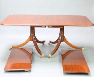 A Georgian style mahogany D end extending dining table with 2 extra leaves, raised on twin pillar, tripod supports ending in brass caps and casters 72cm h x 102cm w x 182cm l x 273cm l when extended 