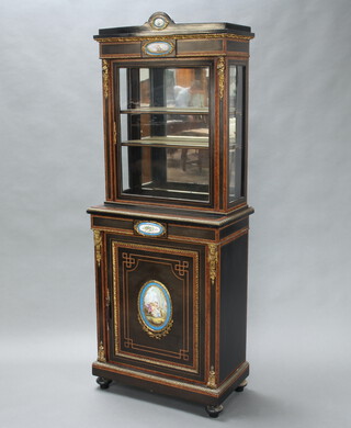 A Victorian amboyna and ebonised display cabinet on cabinet, the upper section with arched top, fitted a cupboard with mirrored back and 2 shelves above a cupboard enclosed by a panelled door, with "Sevres" plaques and gilt metal mounts throughout, raised on bun feet 192cm h x 73cm w x 41cm d 