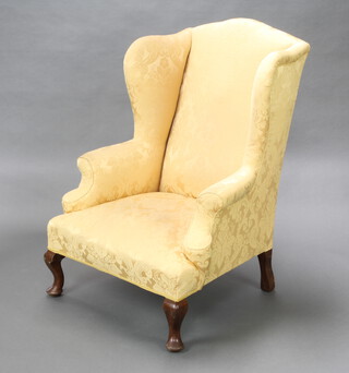 A Georgian style winged armchair upholstered in yellow material raised on cabriole supports 111cm h x 79cm w x 70cm d (seat 42cm x 40cm) 
