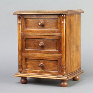 A hardwood apprentice style chest of 3 drawers with tore handles, raised on bun feet 30cm h x 25cm w x 18cm d 