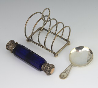 A silver 5 bar toast rack on ball feet Birmingham 1911, a silver caddy spoon Sheffield 1921 and a mounted double ended Victorian blue glass scent bottle 