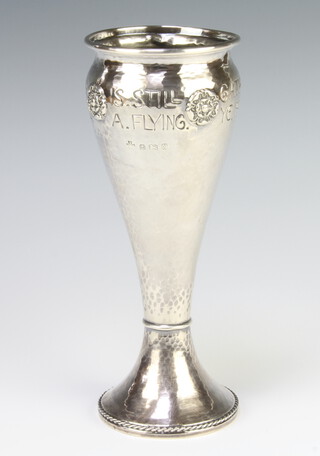 A silver Liberty style Arts & Crafts hammer pattern vase with applied roundels, engraved 'Gather ye roses while ye may, old time is still a flying' Birmingham 1922 17.25cm 