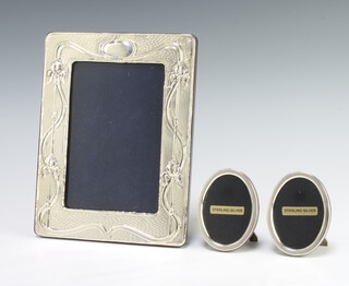 An Art Nouveau style repousse silver photograph frame 19cm x 14cm, 2 oval ditto 