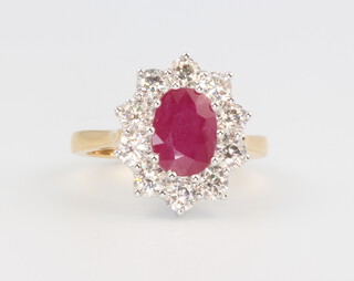 An 18ct yellow gold oval ruby and diamond cluster ring, the centre stone approx. 2.25ct, surrounded by brilliant cut diamonds approx. 1.5ct, 5.9 grams, size M 