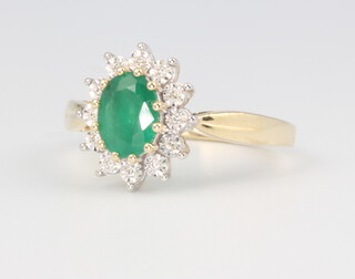A 9ct yellow gold oval emerald and diamond cluster ring, the centre stone 1.05ct, the brilliant cut diamonds 0.06ct, 3.6 grams, size P 1/2