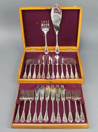 An Edwardian silver plated service of 6 pairs of fish eaters and servers with lily handles, contained in an oak canteen 