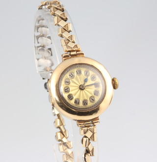 A lady's 9ct yellow gold wristwatch contained in a 25mm case on an expanding gilt bracelet 