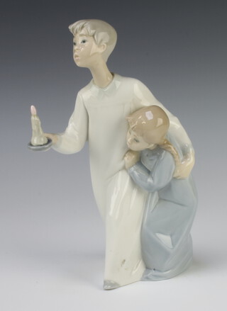 A Lladro figure of a girl and boy, the boy holding a candle 20cm 