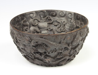 A Chinese carved composition bowl decorated with dragons chasing the flaming pearl above waves 15cm 