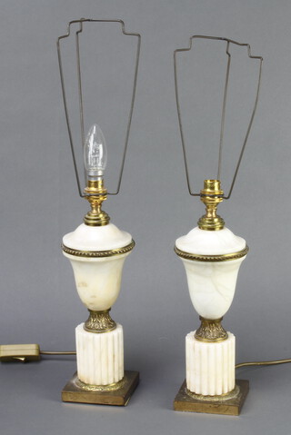 A pair of gilt metal and alabaster table lamps in the form of urns on square feet 28cm h x 10cm w x 10cm d 