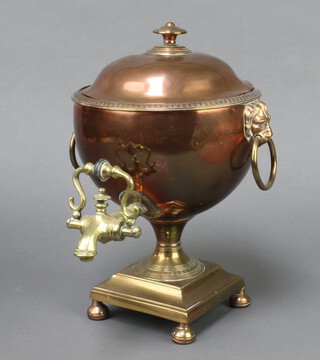 A Regency copper and brass tea urn with lion ring drop handles, raised on a square base with bun feet 33cm h x 13cm w x 12cm d 