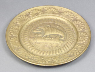A circular Art Nouveau, Newlyn style, embossed brass charger decorated a long boat 46cm diam.  
