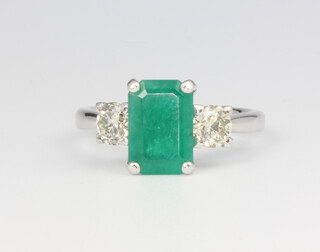 An 18ct white gold emerald and diamond ring the baguette cut emerald approx. 1.92ct, the 2 brilliant cut diamonds 0.81ct, 4.2 grams, size M 1/2, with WGI certificate 