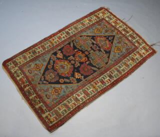 A North West Persian red and blue ground rug with shaped medallion to the centre within a multi row border 211cm x 128cm 