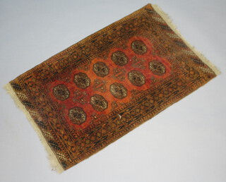 A brown and black ground Afghan rug with 10 octagons to the centre within multi row border 126cm x 82cm 