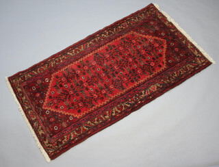 An Afghan red and blue ground rug with diamond shaped medallion to the centre 197cm x 107cm 