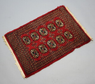 A red and black ground Bokhara rug with 10 octagons to the centre 90cm x 63cm 