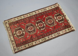 A brown, white and red ground Persian rug with 5 octagons to the centre and bird decoration 120cm x 72cm 