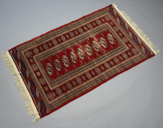 A red and white ground Bokhara rug with 9 octagons to the centre within a multi row border 156 cm x 95cm 