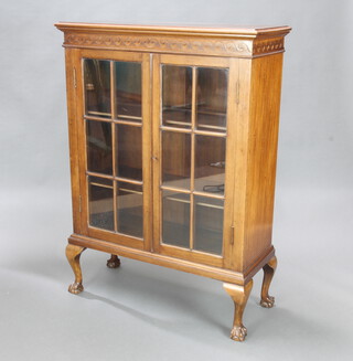 A 1930's mahogany display cabinet with moulded cornice, fitted shelves enclosed by astragal glazed panelled doors, raised on cabriole, ball and claw supports 126cm h x 91cm w x 37cm d 