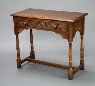 An Ipswich style carved oak side table fitted a frieze drawer, raised on turned and block supports 76cm h x 90cm w x 43cm d 