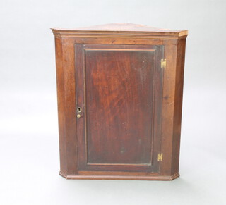 A Georgian mahogany hanging corner cabinet with moulded cornice, fitted shelves enclosed by a panelled door 103cm h x 85cm w x 52cm d 