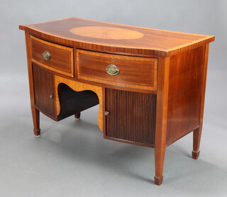 A Georgian style inlaid mahogany bow front sideboard, the top with inlaid oval panel, fitted 2 drawers above pair of cupboards enclosed by tambour shutters, raised on square tapered supports, spade feet 93cm h x 134cm w x 68cm d 