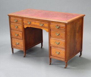 A Victorian mahogany kneehole desk with red inset writing surface above 1 long and 8 short drawers with brass drop handles 76cm h x 121cm w x 60cm d 