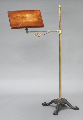 A 19th Century mahogany, brass and iron adjustable reading stand, raised on a cast iron triform base with paw feet 121cm h x 56cm w 