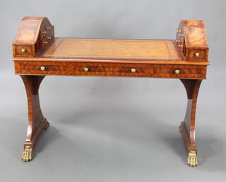 Maitland-Smith, a Georgian style figured mahogany library table with arched sections to the sides fitted 8 drawers and pigeon holes, the base fitted 1 long and 2 short drawers, raised on out swept supports with gilt metal paw feet 95cm h x 122cm w x 61cm d 