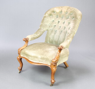 A Victorian walnut showframe armchair upholstered in green buttoned material, raised on cabriole supports 88cm h x 61cm w x 54cm d (seat 30cm x 41cm) 