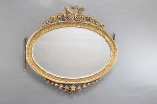 A Georgian style oval bevelled plate mirror contained in a decorative gilt frame surmounted by swag, torch and quiver to the top 105cm 