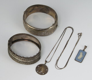 Two silver bangles, a pendant and chain and a mounted pendant 