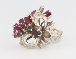 A white metal stamped 18k, ruby and diamond scroll ring 6.7 grams, size L 1/2, with original import tax certificate for 1969 