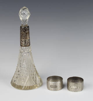 A pair of silver engine turned napkin rings Birmingham 1967, 54 grams, together with a silver mounted tapered glass scent 