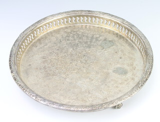 A middle Eastern silver plated tray with pierced rim on claw and ball feet 27cm