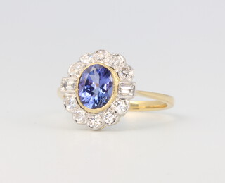 An 18ct yellow gold oval tanzanite and diamond cluster ring, the centre oval cut stone 1.45ct, the brilliant cut diamonds 0.6ct, 3.1 grams, size O 1/2