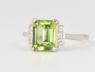 A platinum peridot and diamond cocktail ring, the centre stone 2ct, flanked by 6 brilliant cut diamonds 0.12ct, size O, 3.8 grams 