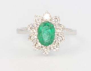 An 18ct white gold oval emerald and diamond ring, the centre cut stone 1.2ct surrounded by 10 brilliant cut diamonds 1ct, size N, 4.8 grams with WGI certificate 