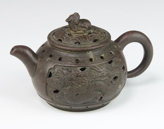 A tanware teapot with reticulated lid and body, the finial in the form of a shi shi, the body with dragons having an impressed seal mark in the recessed base 14cm 