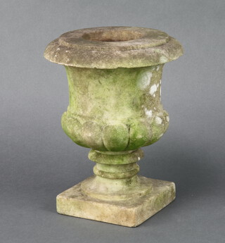 A well weathered carved stone urn, raised on a square base 21cm h x 11cm w x 11cm d 