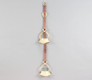 A curious pair of gilt metal boat shaped stirrups 15cm x 12cm x 6cm hung on a leather hanger 