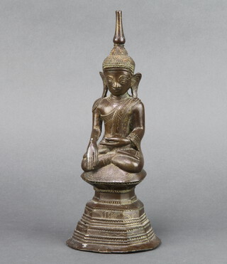 A bronze figure of a seated buddha raised on a shaped base 25cm x 10cm x 9cm 
