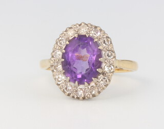 An 18ct yellow gold oval amethyst and diamond cluster ring, 4.4 grams, size M 1/2