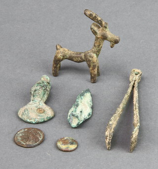 A bronze arrowhead, a Roman bronze spoon in the form of a bust, 2 coins, pair of tweezers and a figure of a goat  